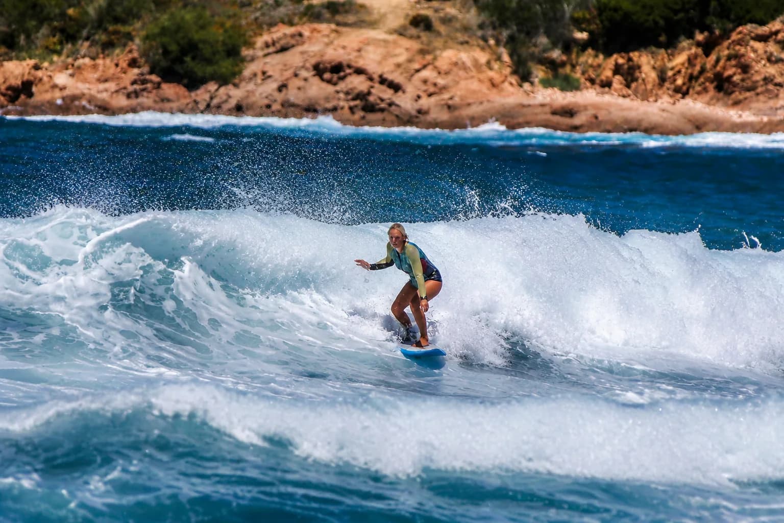 A surfer riding wind-driven waves at Isola Rossa