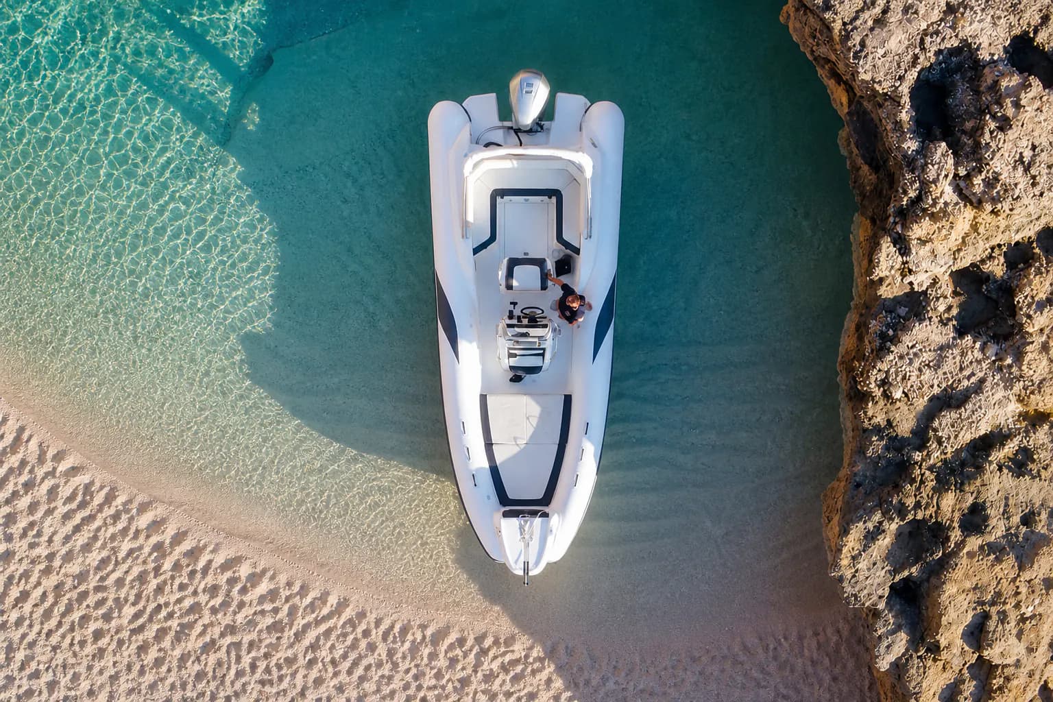 A rigid-inflatable boat in a shallow Gulf of Orosei cove